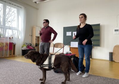 Nevidomí Lukáš a Denisa s vodicím psem Glissou ve třídě na workshpu pro děti.